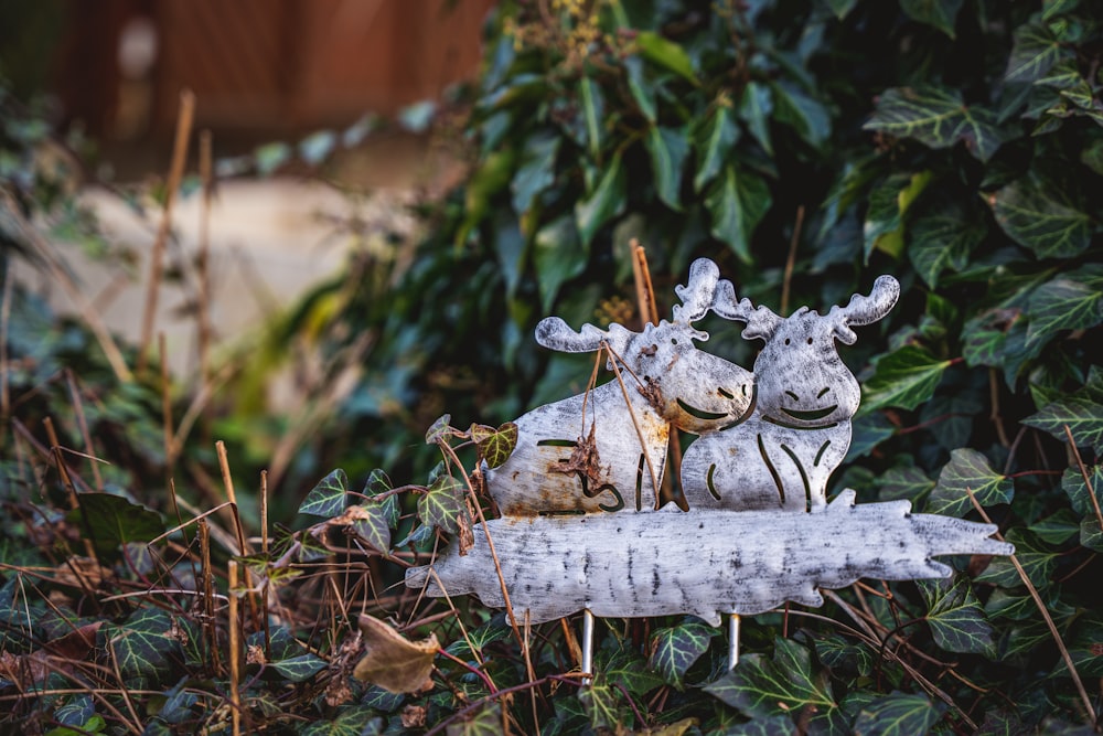 a statue of two giraffes sitting on top of a log