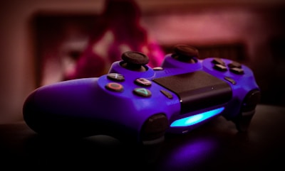 Close-up of a vibrant gaming controller on a desk with colorful LED lights.