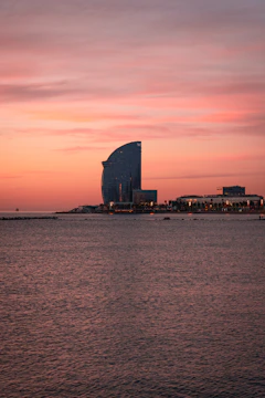 An elegant office tower in Muscat reflecting the golden sunset.