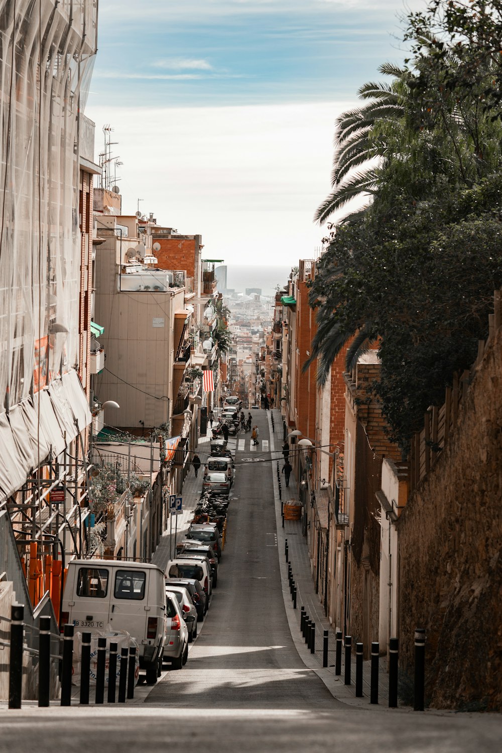 a street lined with parked cars next to tall buildings