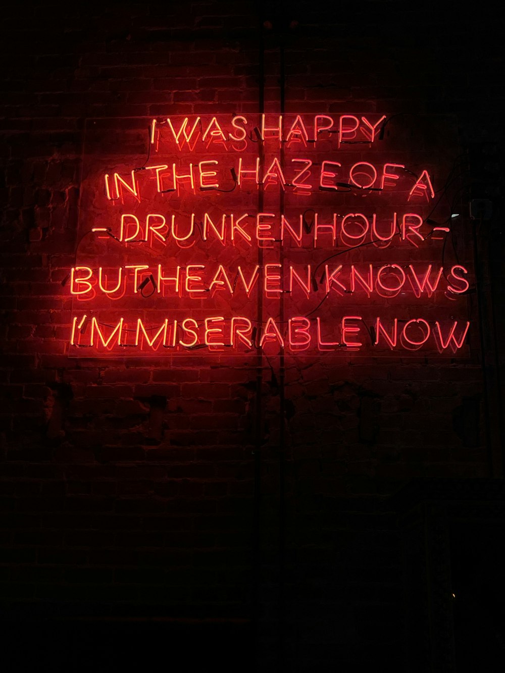 a red neon sign that says i was happy in the haze of a drunk hour