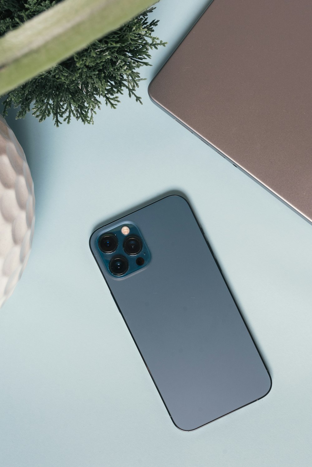 a cell phone sitting on top of a table next to a plant