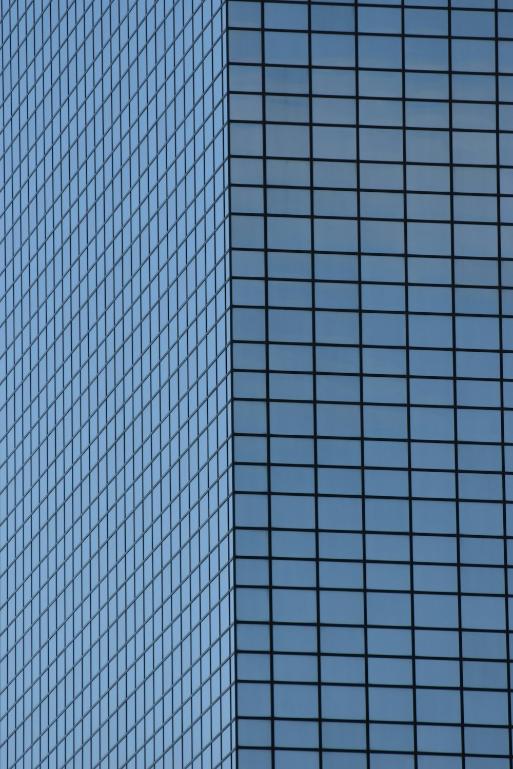 a plane flying in front of a very tall building