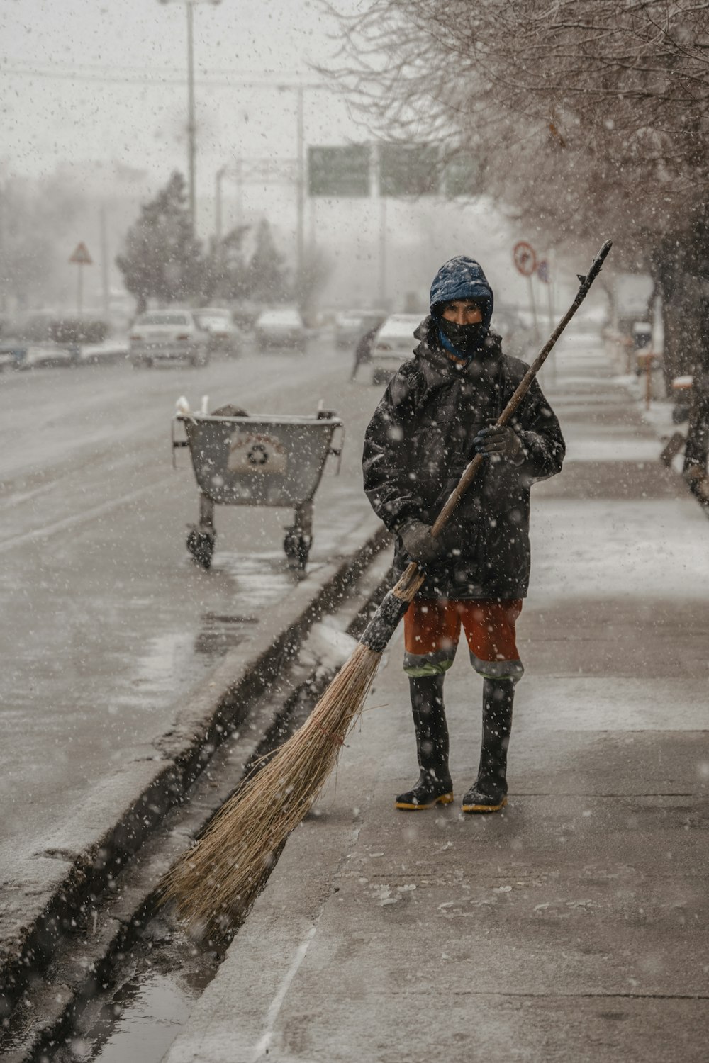 a person with a broom on a snowy street