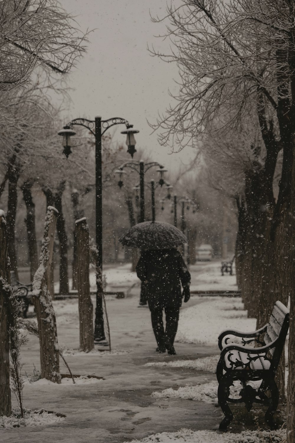 a person walking in the snow with an umbrella