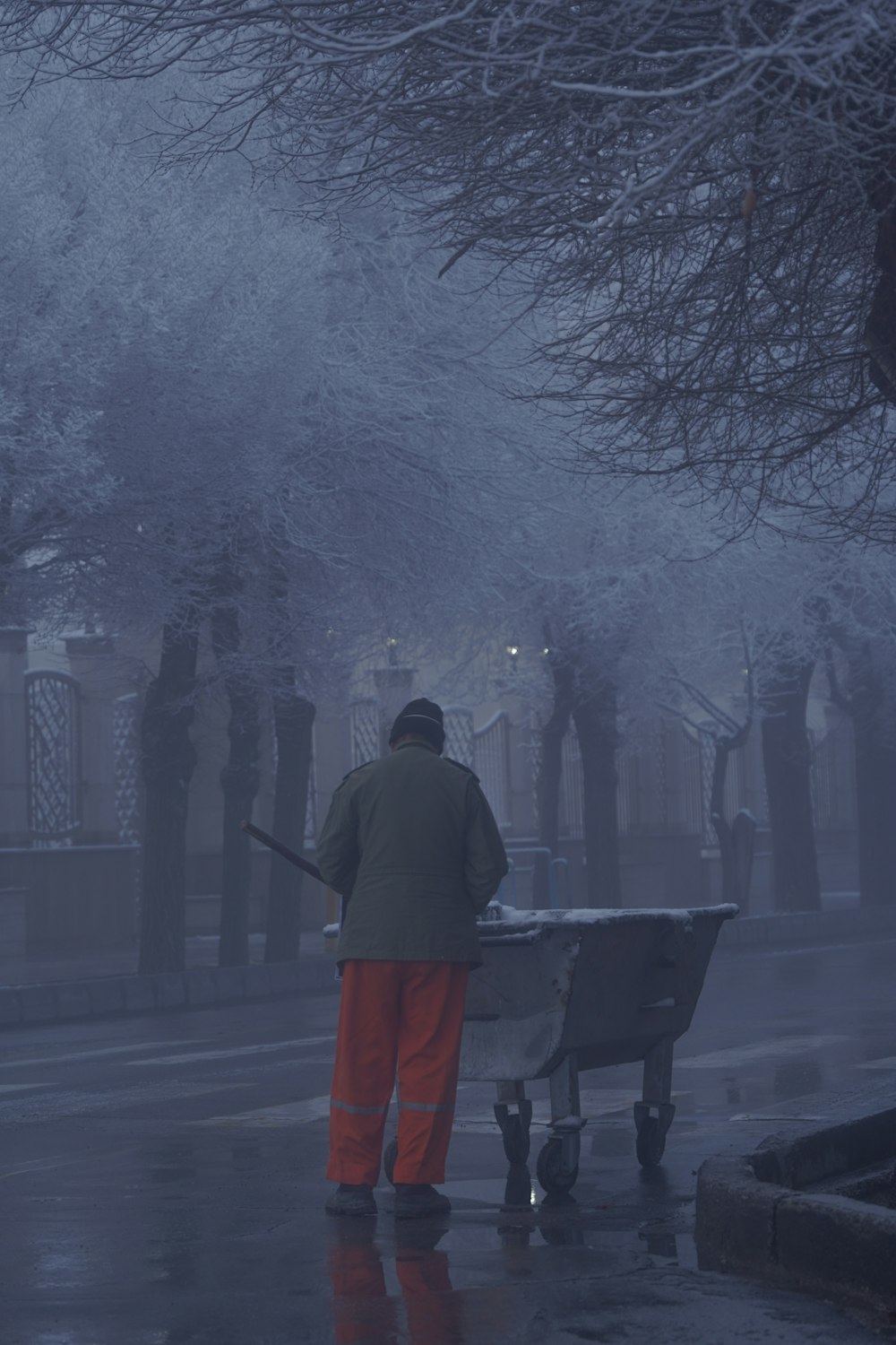 a man pushing a wheelbarrow in the rain