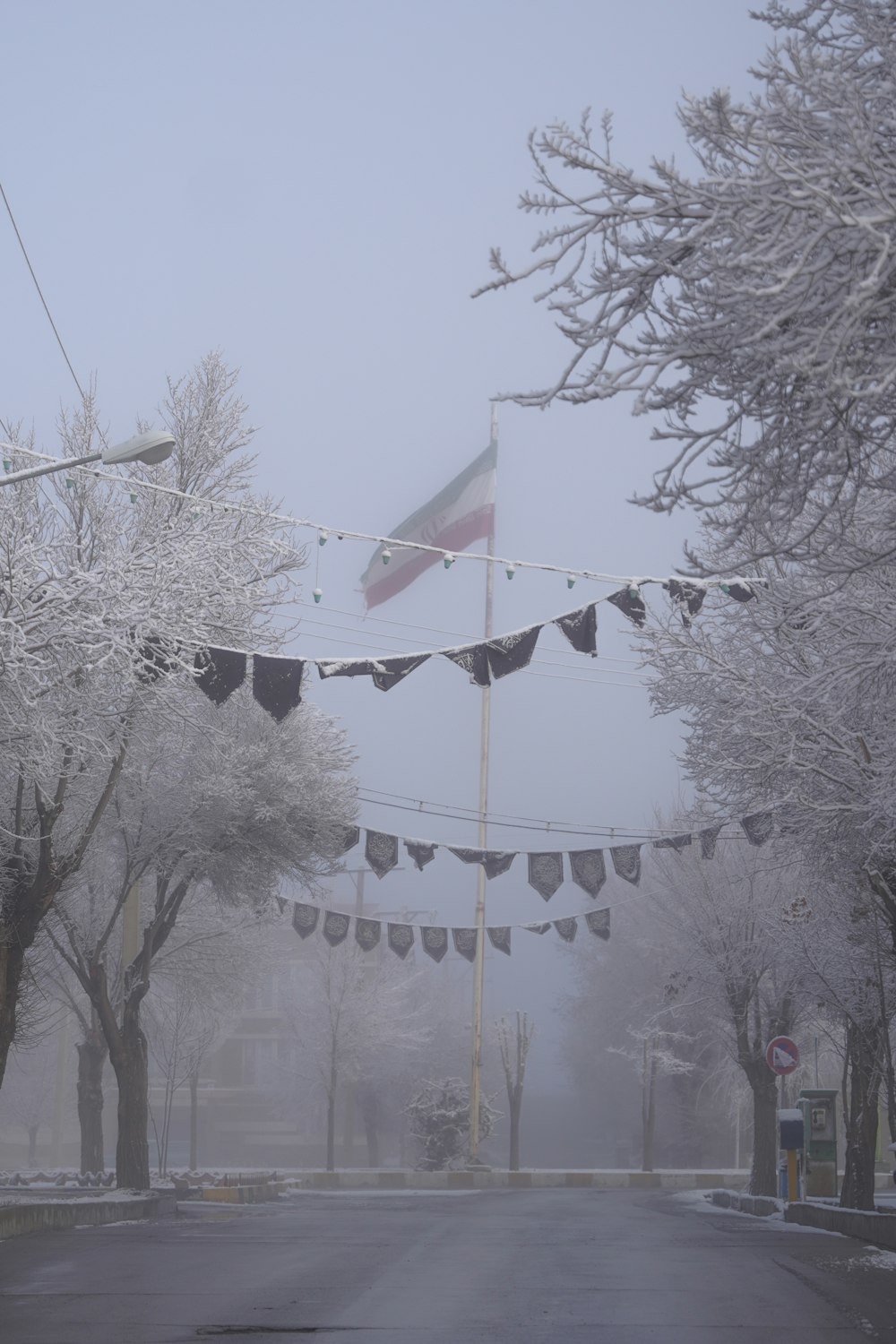 a foggy street with a flag hanging from a line