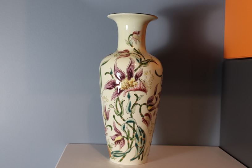 Close-up of a delicate purple ceramic vase with intricate hand-painted floral patterns.