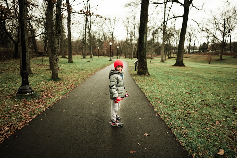 Ein kleines Mädchen steht auf einem Weg in einem Park