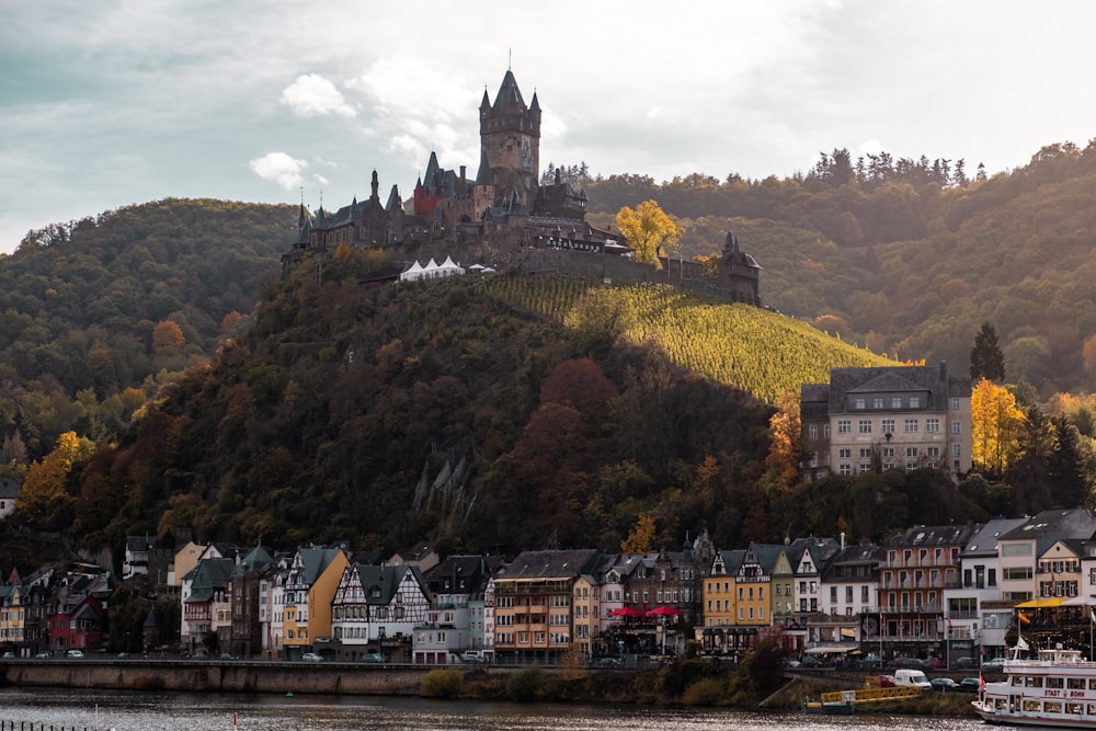 a castle on top of a hill next to a body of water