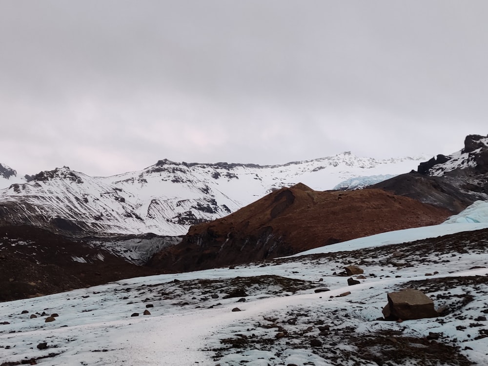 a snow covered mountain range with a glacier in the foreground