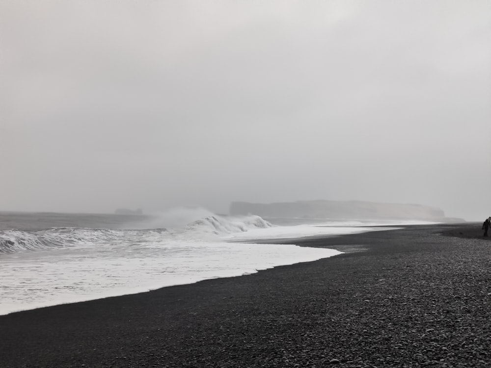 a person standing on a beach next to the ocean