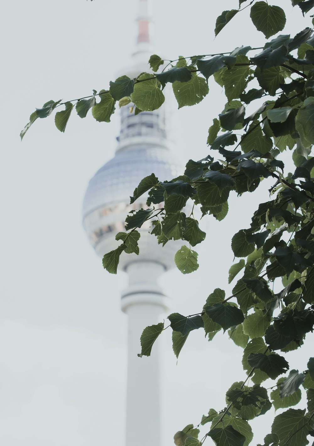 a tall white tower with a clock on it's side