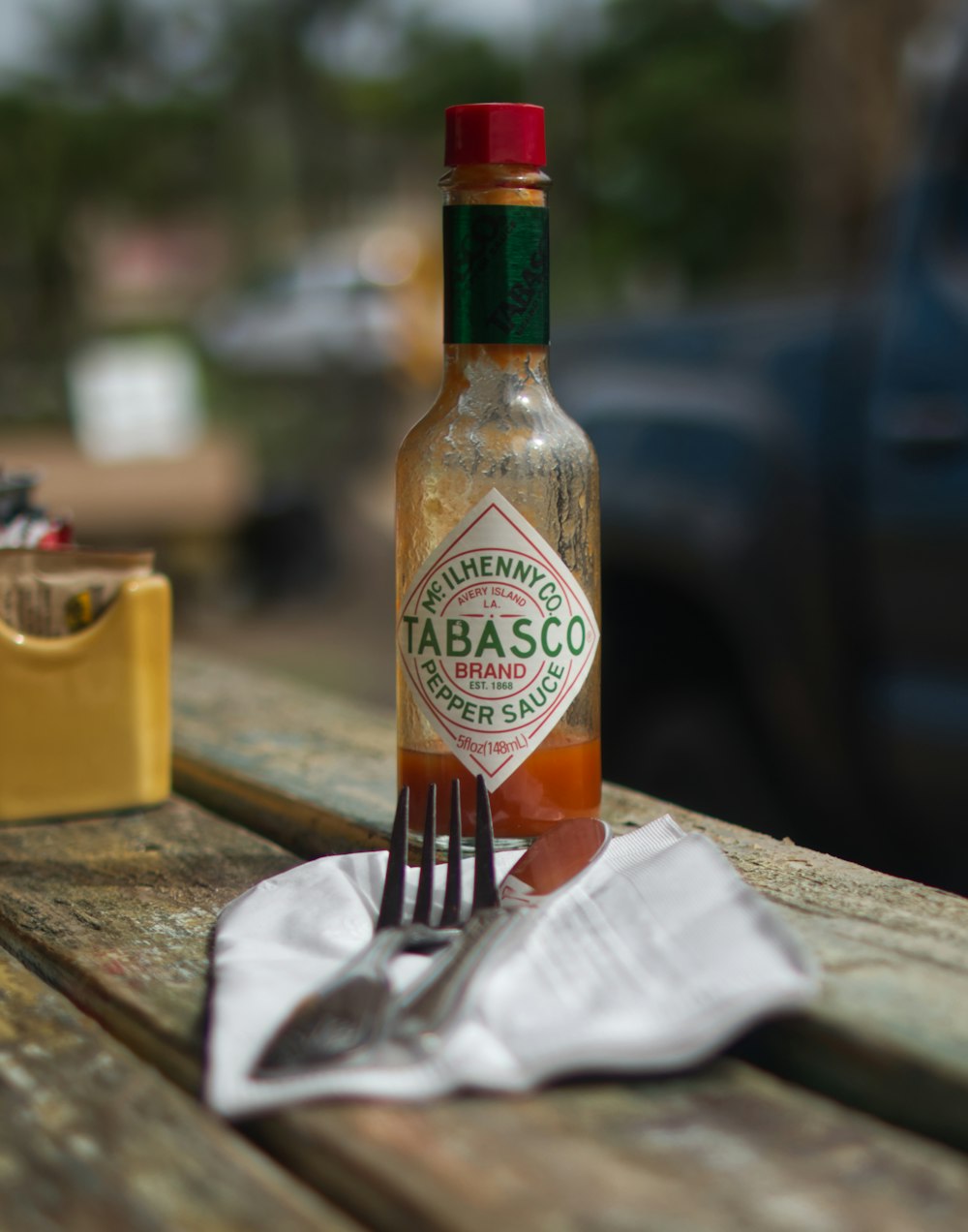 a bottle of tabasco sitting on top of a wooden table