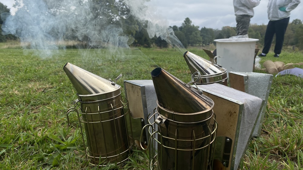 a bunch of trash cans sitting on top of a lush green field