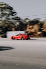 a red sports car driving down a street