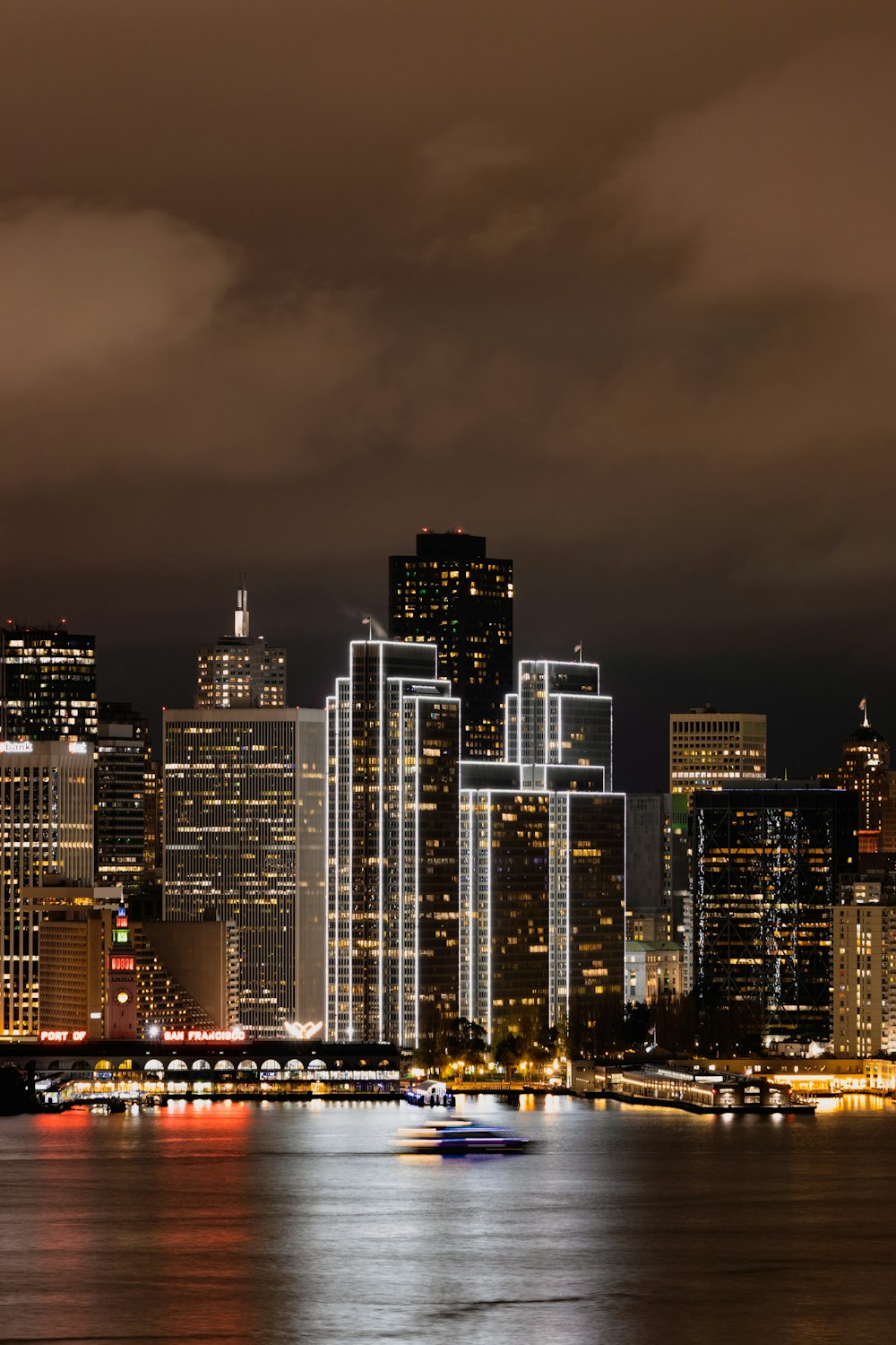 Eine Skyline der Stadt bei Nacht mit einem Boot im Wasser