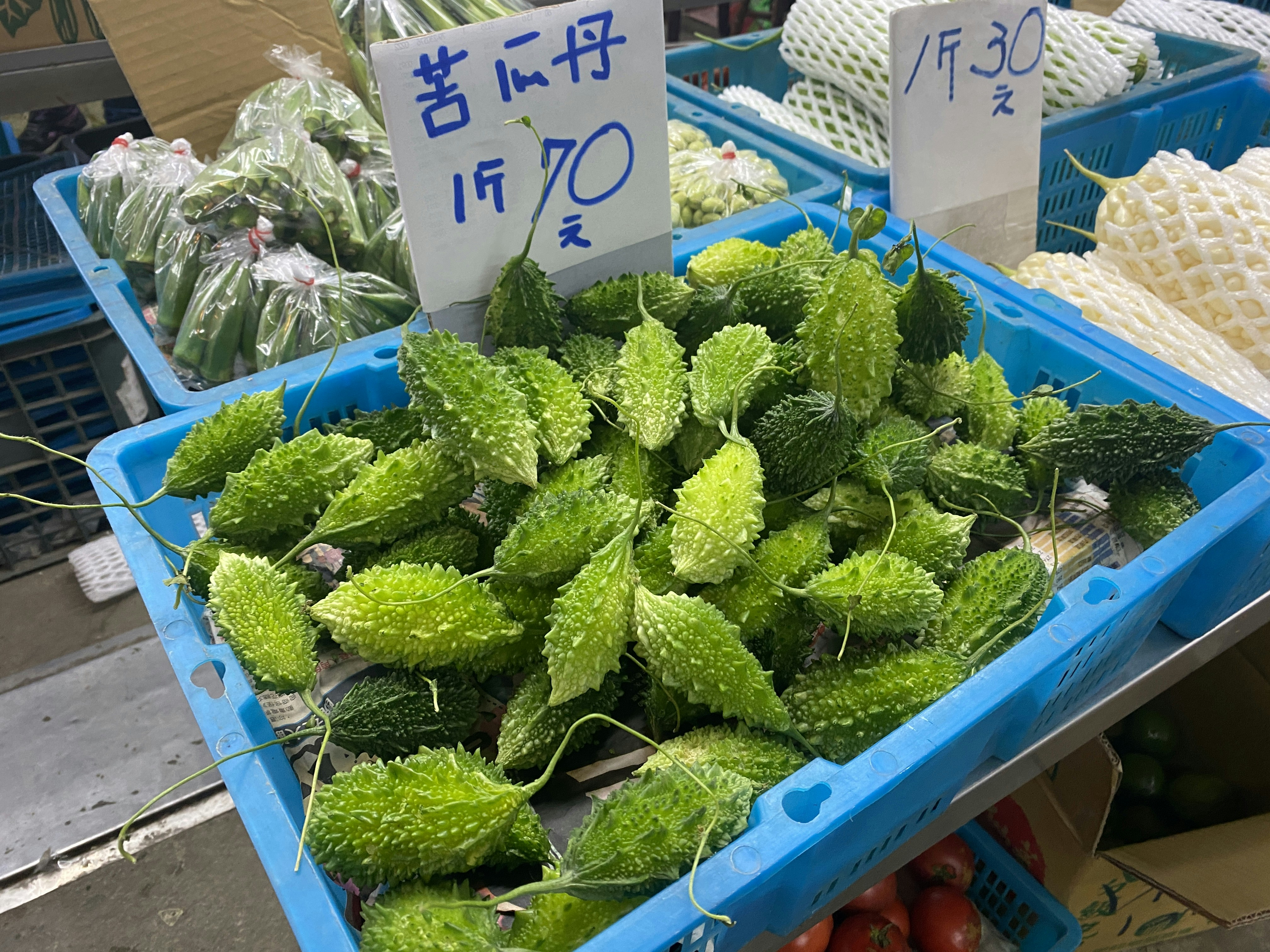 Fresh bitter gourd vegetables in a basket on a wooden surface