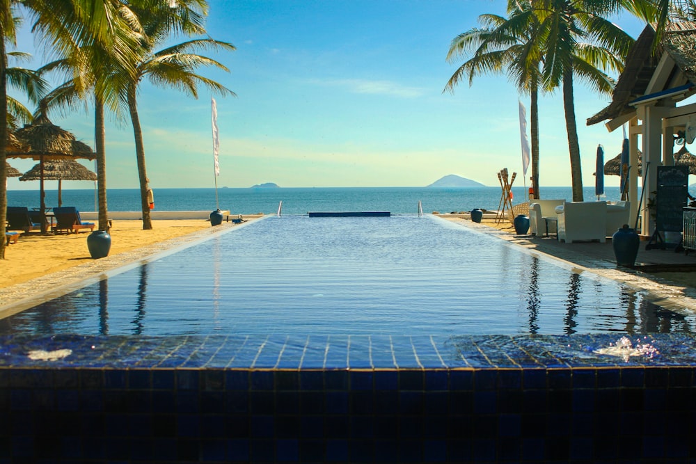 a large swimming pool surrounded by palm trees