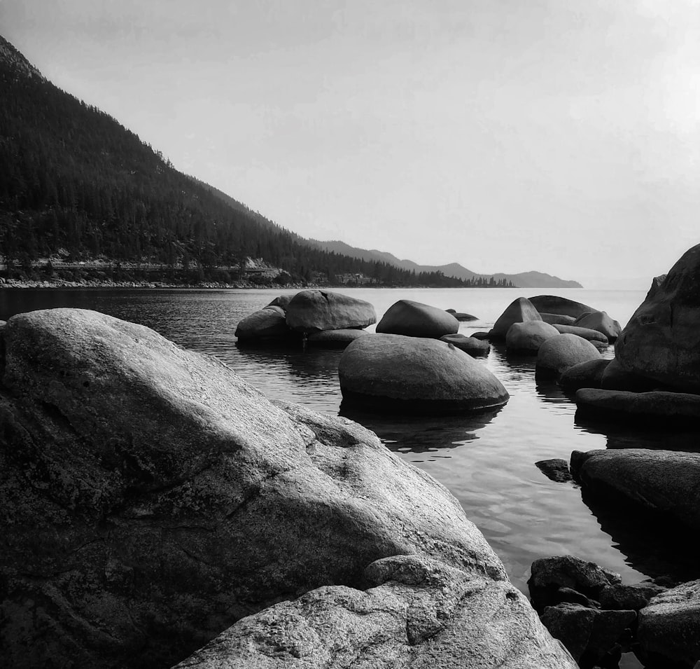 a black and white photo of rocks in the water