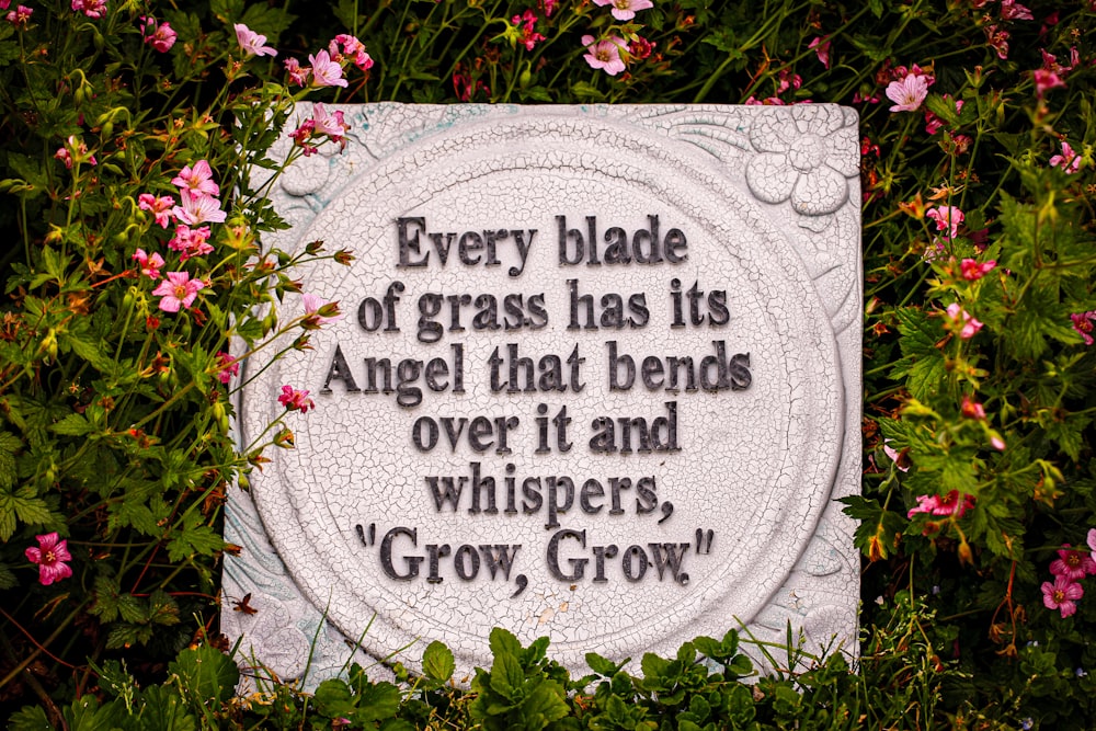 a plaque with a quote on it surrounded by flowers