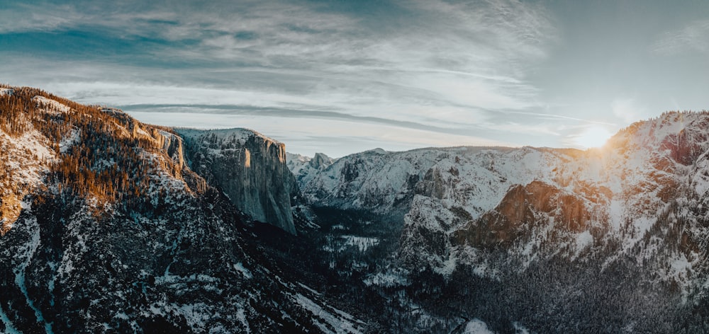 the sun is shining on the mountains in the winter