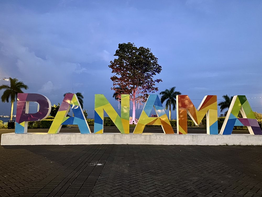 Un grand panneau qui dit Panama avec un arbre en arrière-plan