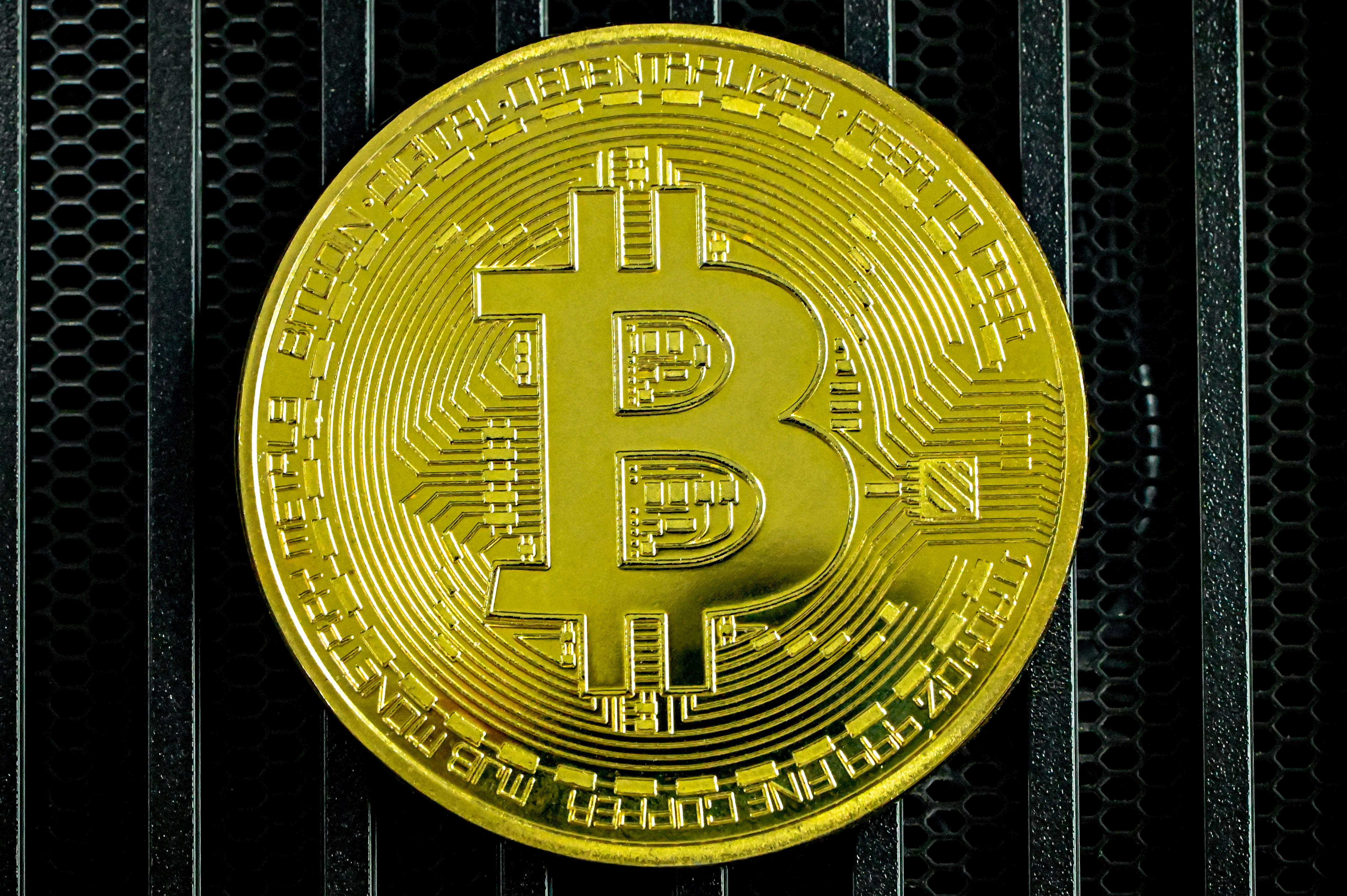 A gold Bitcoin on a dark surface