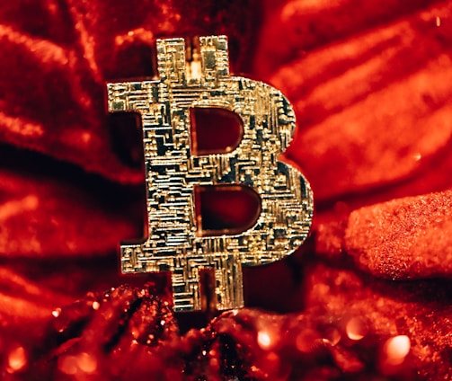 a golden bitcoin sitting on top of a red blanket