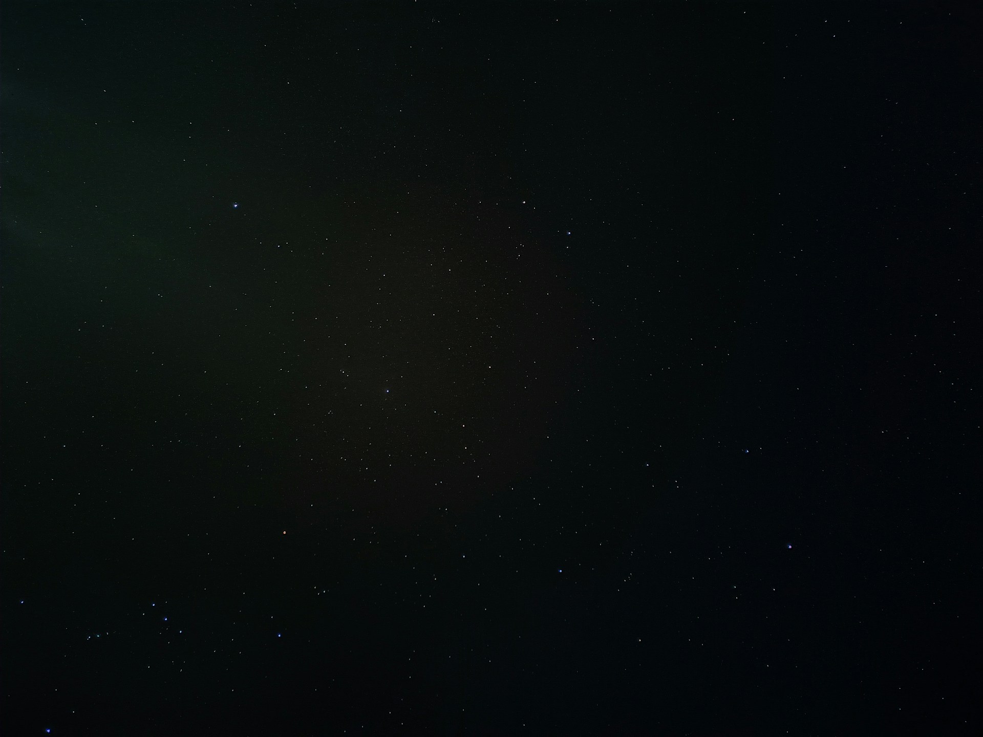 a black sky with stars and a bright light