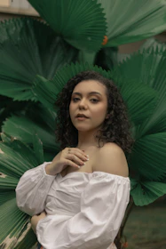 a woman standing in front of a green plant