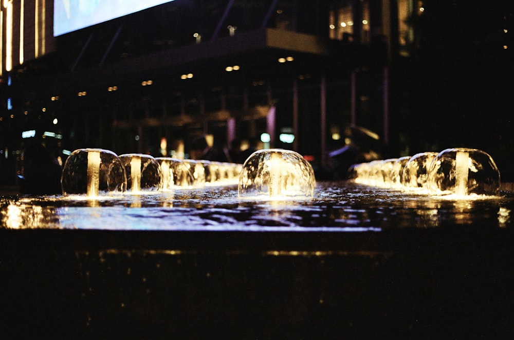 a group of water fountains in front of a building