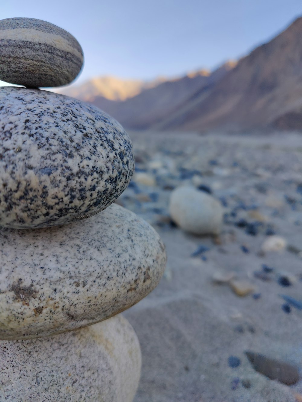 uma pilha de rochas sentadas no topo de uma praia de areia
