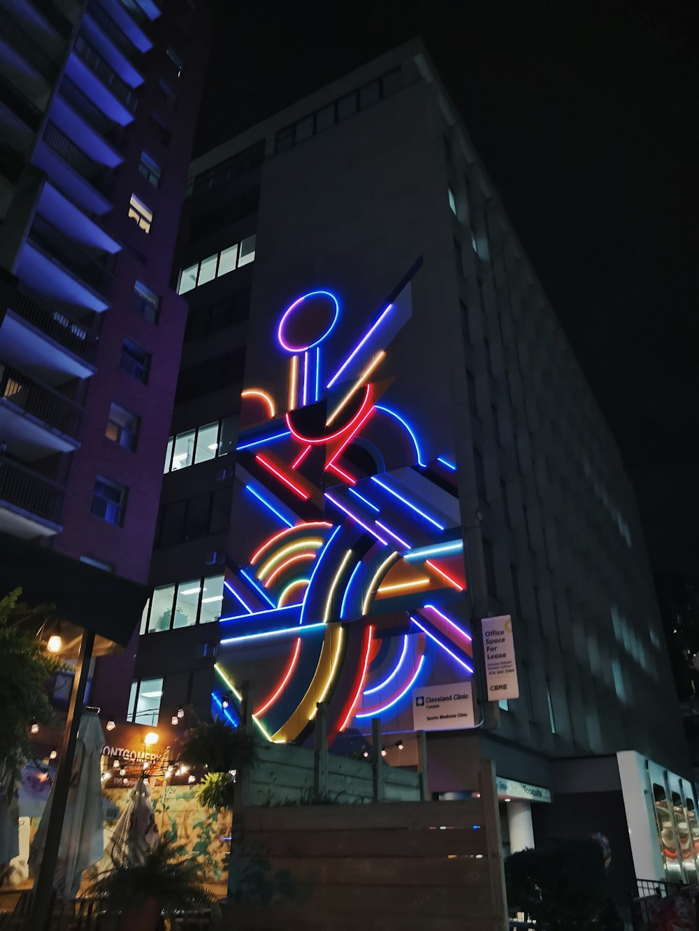 a tall building with a neon sign on the side of it