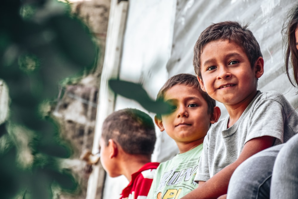 un gruppo di bambini piccoli seduti uno accanto all'altro