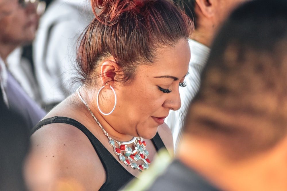 a woman wearing a black top and a pair of large hoop earrings