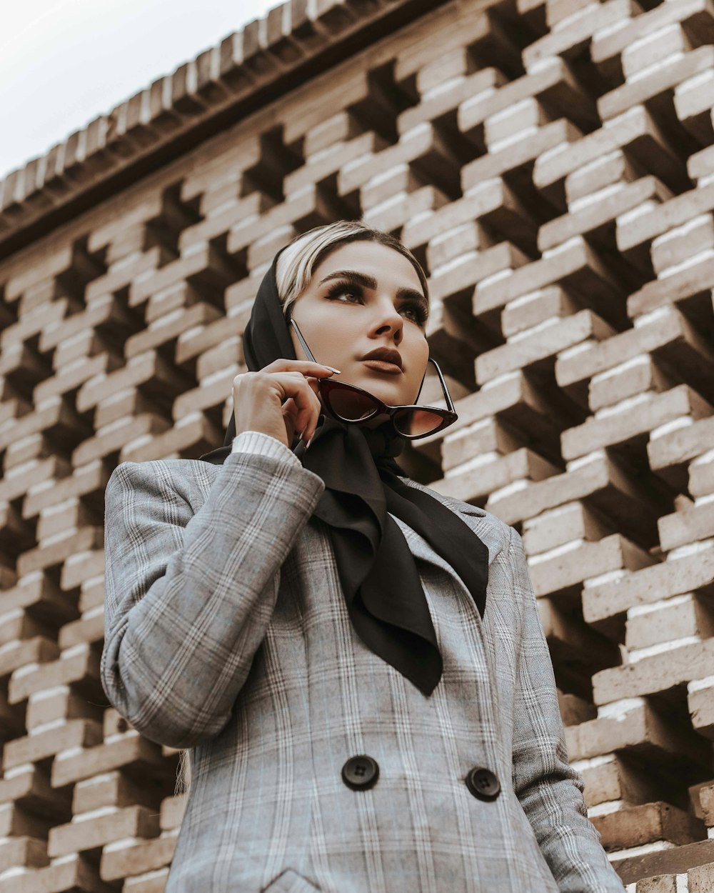 a woman in a suit and scarf talking on a cell phone