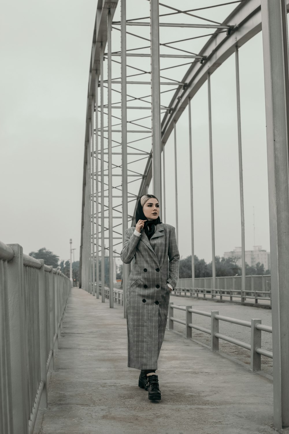 a woman standing on a bridge talking on a cell phone