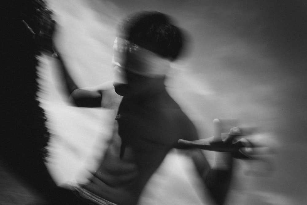 a blurry image of a man holding a skateboard