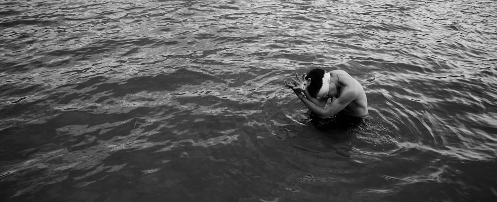 a man in a body of water holding a camera