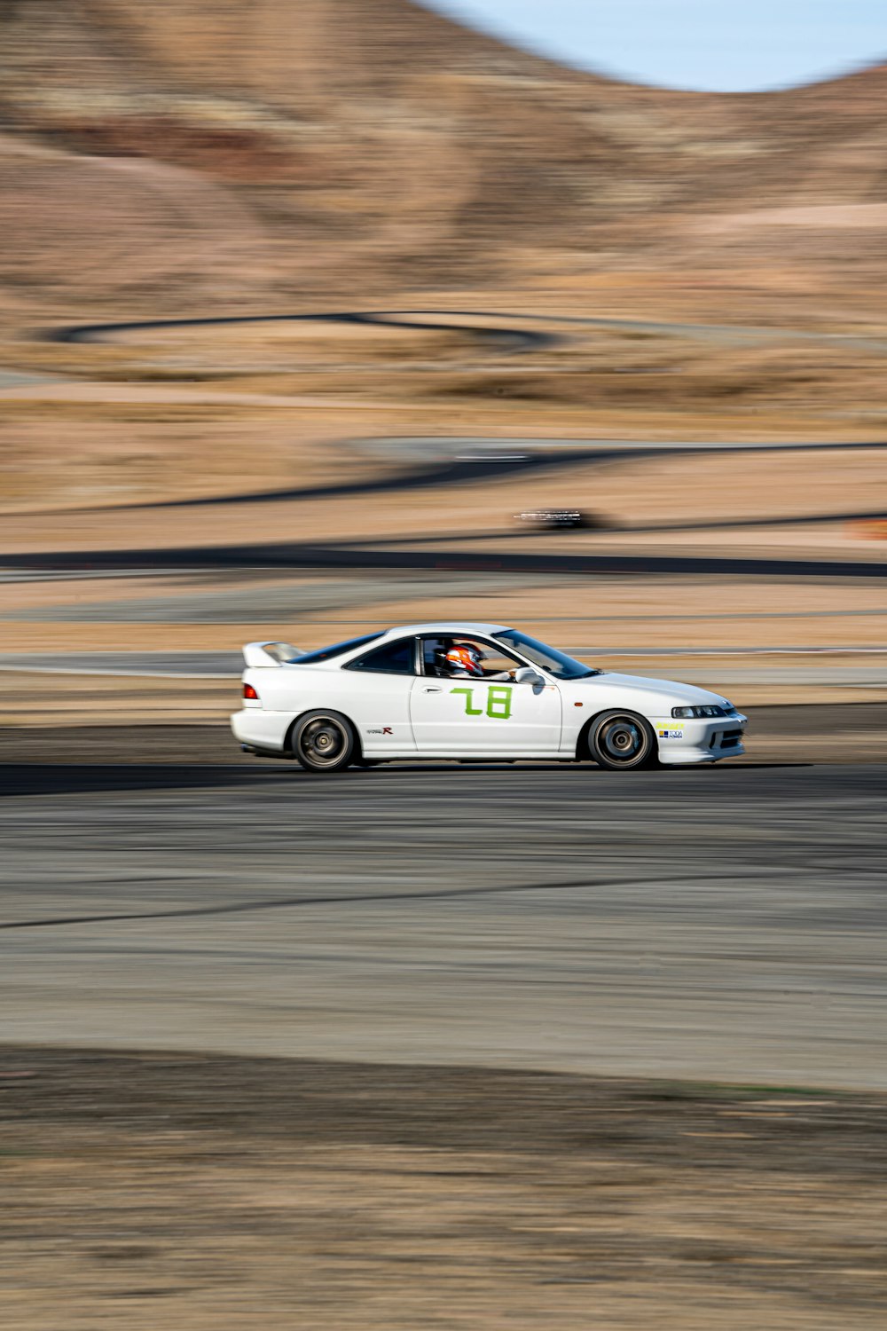 a white car driving down a race track