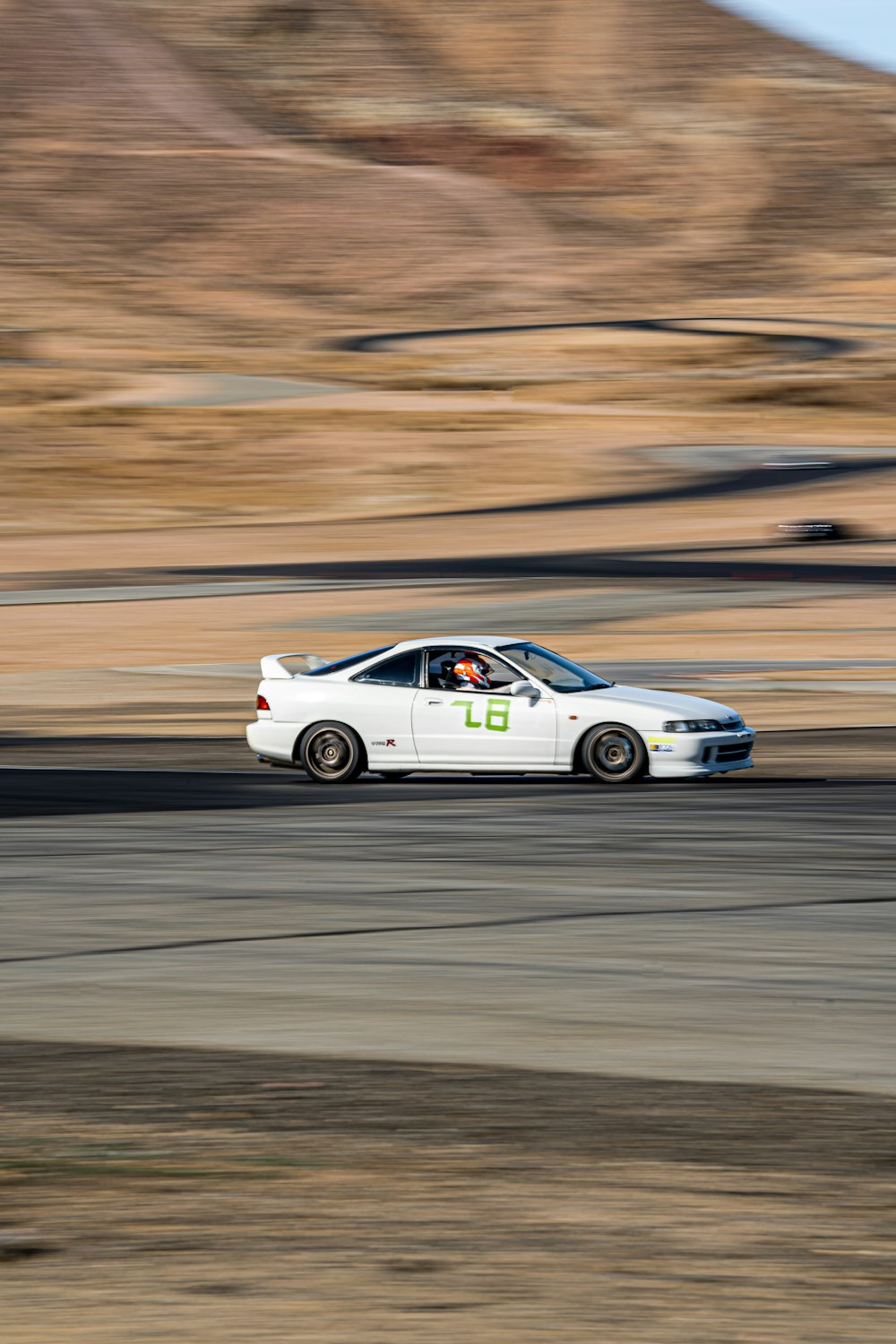 a white car driving down a race track