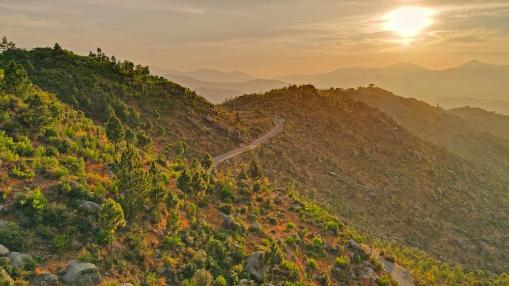 a scenic view of a mountain with a winding road in the foreground