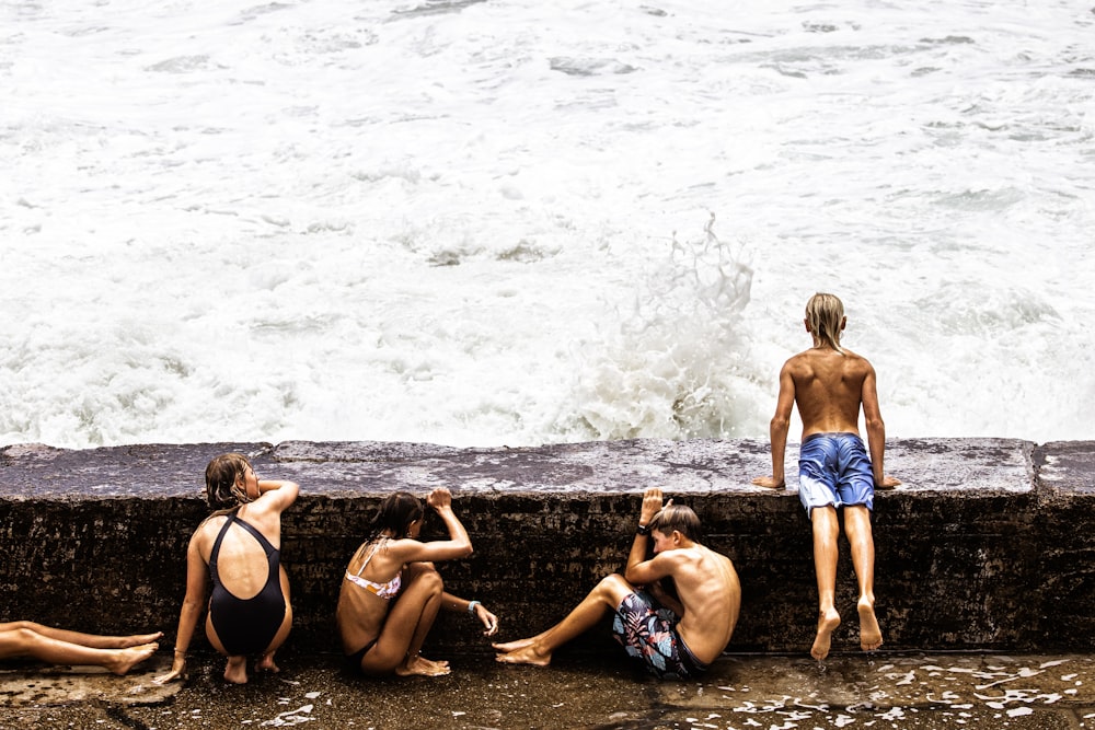 a group of people sitting next to a body of water