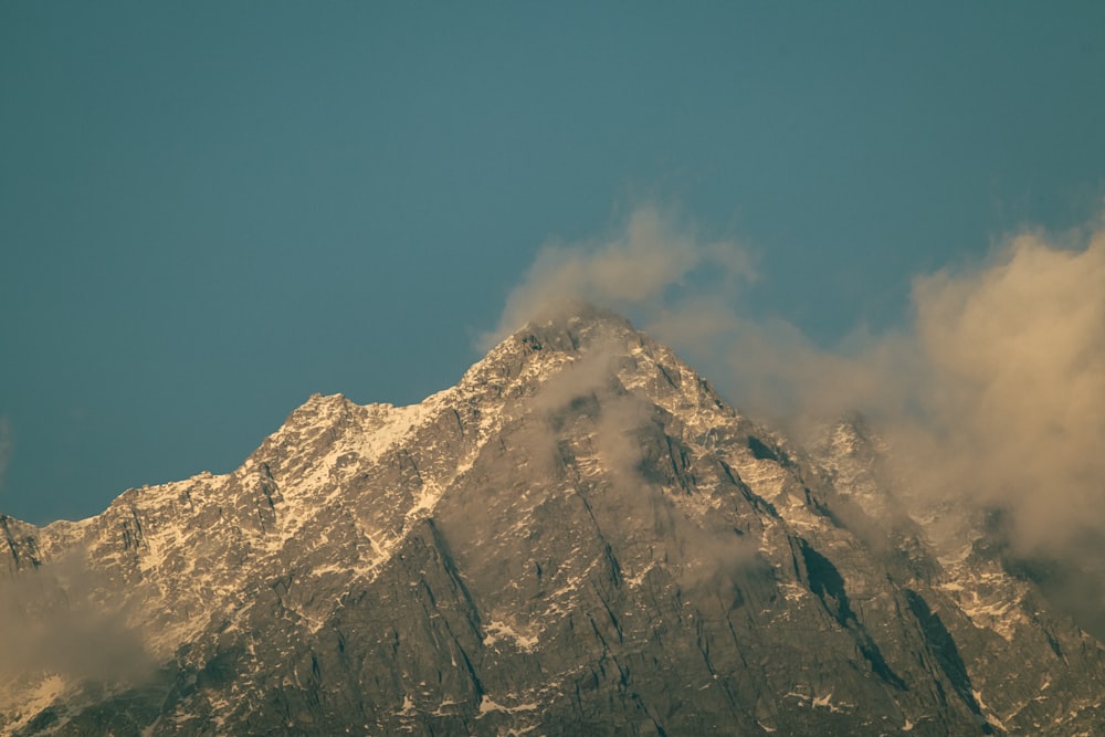 a large mountain covered in snow under a blue sky