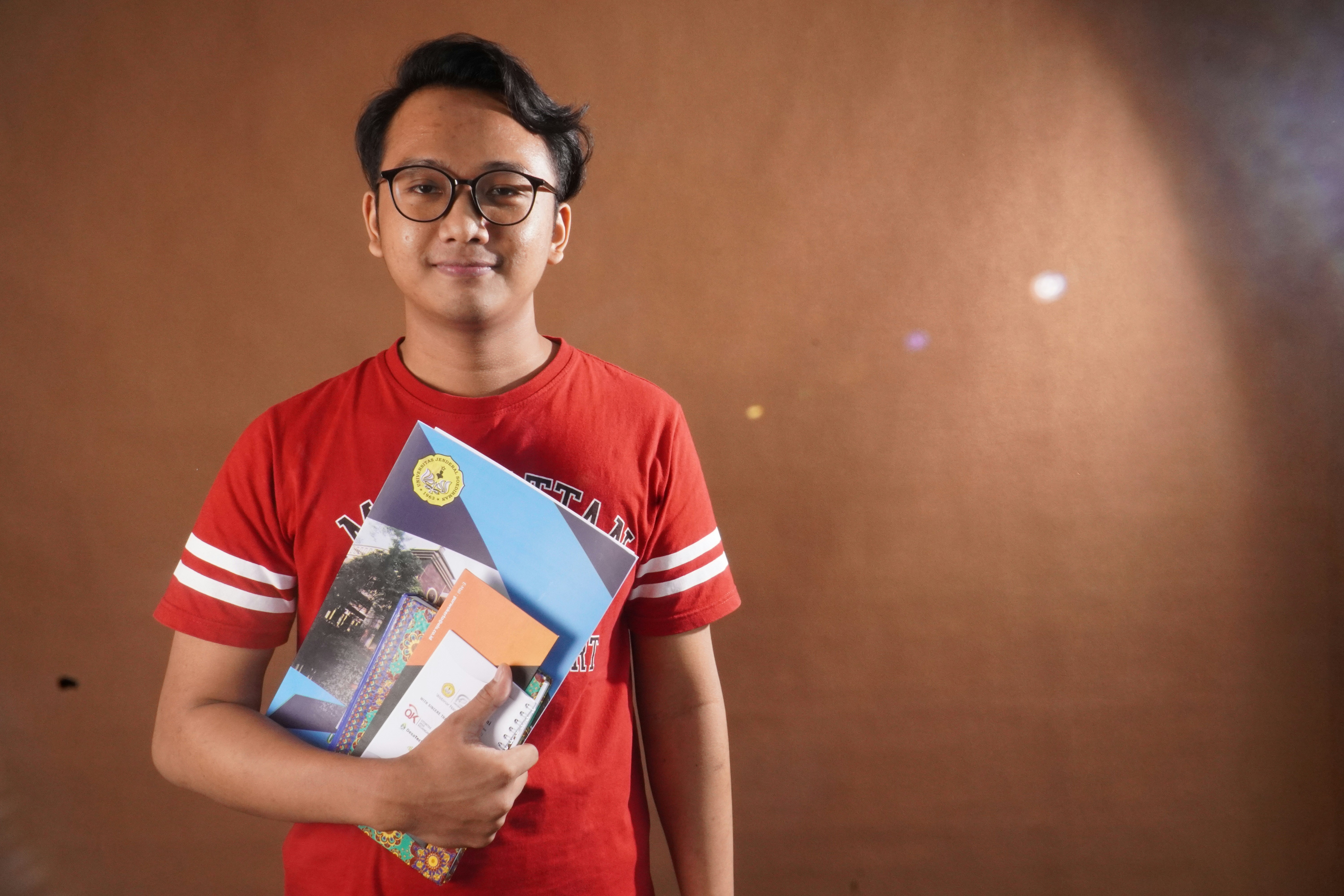 a young man holding a book in his hands