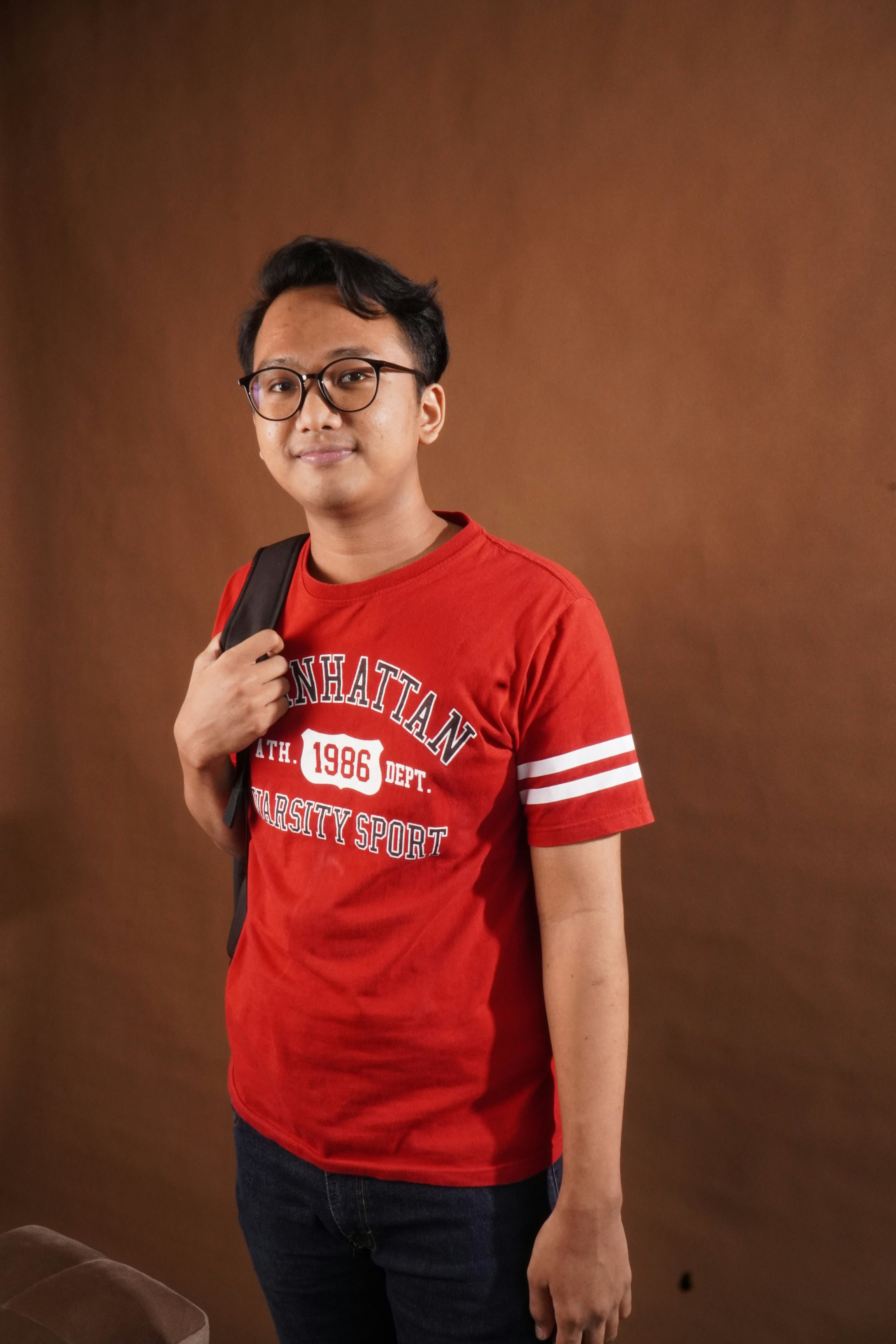 a young man wearing a red shirt and glasses