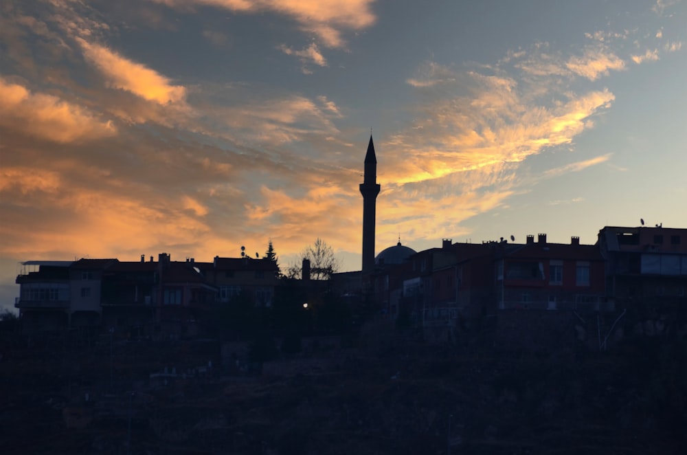 a tall clock tower towering over a city under a cloudy sky