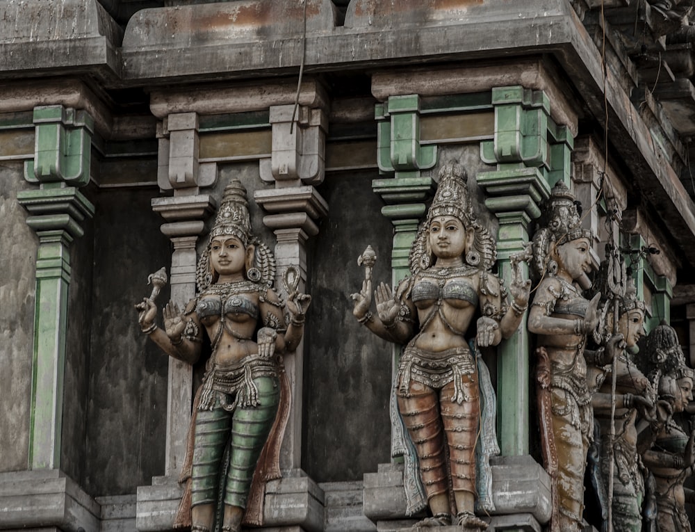 a couple of statues on the side of a building