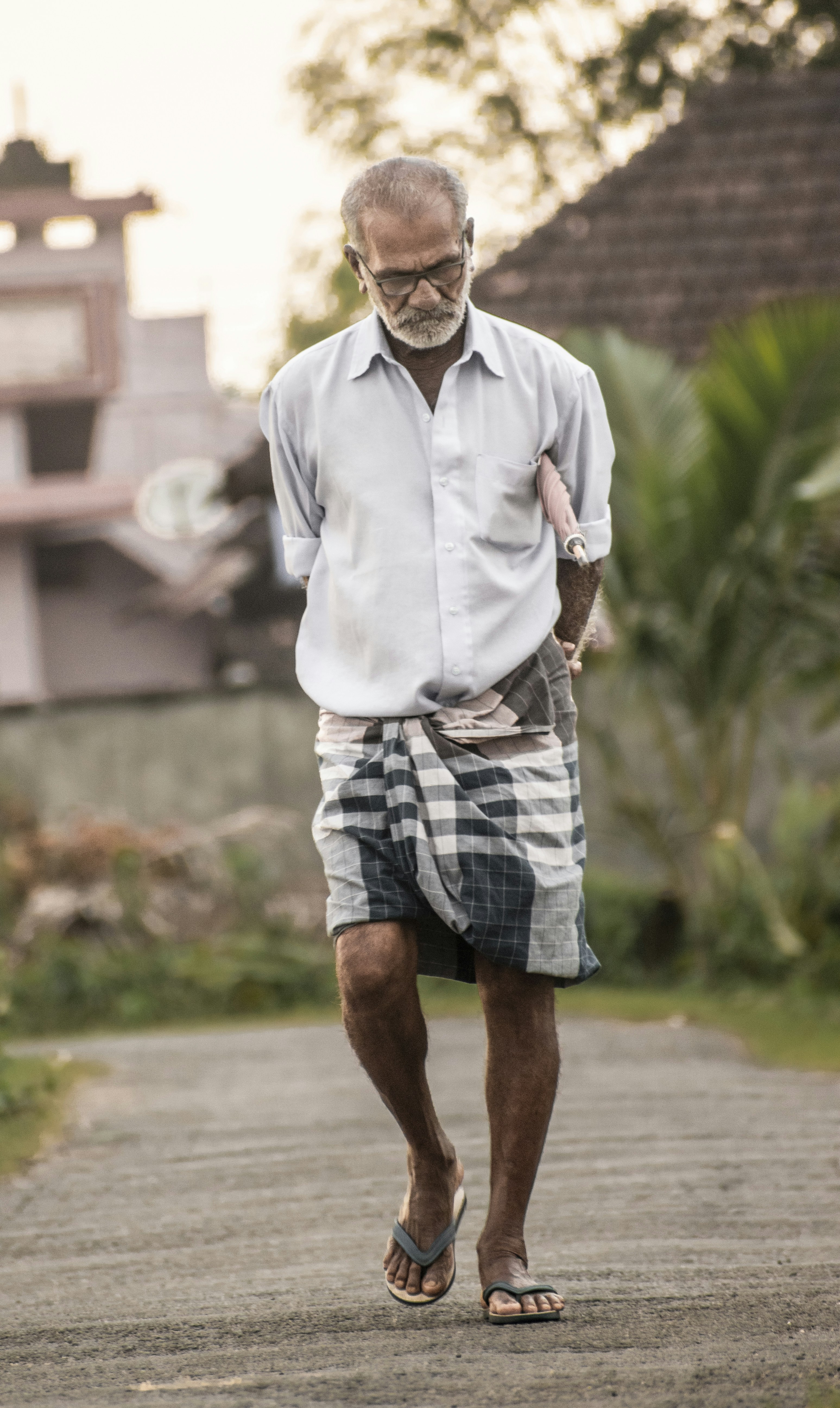 a man walking down a road with a bag on his shoulder